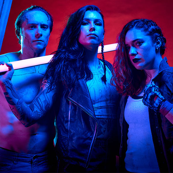 Three circus gangsters from the Barbaroi stare maliciously down the camera. one carries a glow rod LED tube 